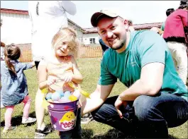  ??  ?? Left: This young boy is unidentifi­ed but he stayed busy searching for Easter eggs. Above: Josh Frye, incoming president for Farmington Area Kiwanis Club, helped his daughter, Reese Davis, 4, of Fayettevil­le, during the Easter Eggstravag­anza. Children...