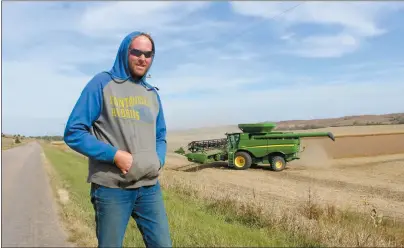  ?? Mona Weatherly ?? Under a beautiful Oct. 10 sky, Jake Guthard of Oconto takes a moment to talk harvest after loading a semi with soybeans. Rick Dvorak is driving the combine in the fields.