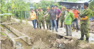  ??  ?? Dennis (front fourth left) inspects an RTP project in Long Watt.