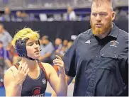  ?? MELISSA PHILLIP/HOUSTON CHRONICLE ?? Mack Beggs, left, a transgende­r wrestler from Euless Trinity High School, stands with coach Travis Clark during a match Friday at the State Wrestling Tournament.