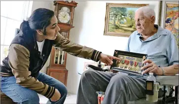  ?? Nikolas Samuels/For The Signal ?? Rishi Sharma, 18, points at the medals earned by U.S. Army veteran Frank Zalusky, 91, prior to an interview on July 14 in Camarillo. Sharma is searching the Santa Clarita Valley to record World War II veterans.