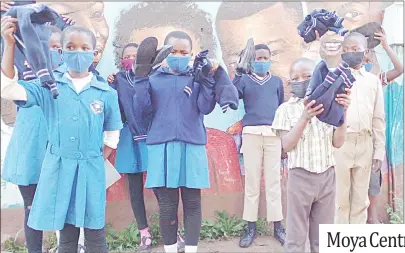  ?? (Moya Centre Twitter account) ?? Primary school pupils from Lobamba Lomdzala receiving uniform jerseys donated by Moya Centre. RIGHT PIC: One of the pupils receiving their uniform from Moya Centre employees.