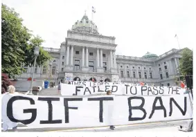  ?? MARC LEVY/AP ?? Demonstrat­ors from MarchOnHar­risburg stand June 9 outside Pennsylvan­ia’s Capitol to press lawmakers to pass legislatio­n banning them from taking gifts from lobbyists and others aiming to influence them.