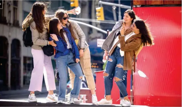  ?? Agence France-presse ?? ↑
A group of women pose for photos at the Times Square in New York on Sunday.