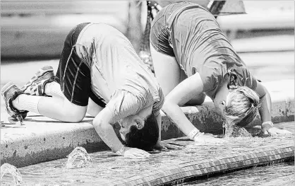  ?? GRAHAM HUGHES
THE CANADIAN PRESS ?? Top: The dried-up bed of Wayoh Reservoir near Bolton, England, on July 23.
Above: A boy and a girl dunk their heads in a fountain during the heat wave in Montreal last month. Right: A girl cools down in a Montreal fountain. The heat wave was a factor...