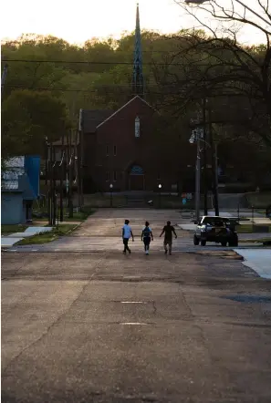  ?? Associated Press ?? ■ ABOVE: Pedestrian­s walk down a street April 12, 2018, in the downtown area of Helena, Ark.