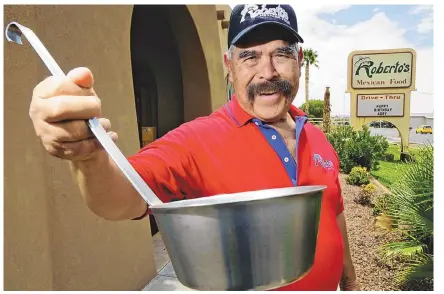  ?? ROBIN ZIELINSKI/LAS CRUCES SUN-NEWS VIA TNS ?? Roberto Estrada poses outside of his restaurant, Roberto’s Mexican Food, in 2013, with a ladle similar in size to the one he used while making his record-setting enchilada at the Whole Enchilada Festival.