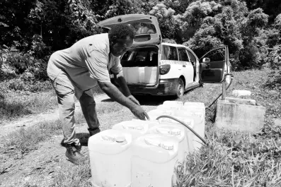  ?? ?? Ludlow Mathison, councillor for the Bath division in St Thomas, fills bottles with water from a standpipe in Needham Pen, St Thomas.