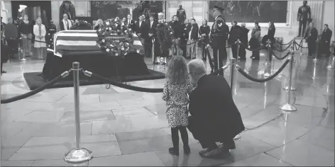  ?? AP PHOTO ?? Rep. Patrick McHenry, R-N.C., kneels alongside his daughter Cecelia near the flag-draped casket of former President George H.W. Bush as he lies in state in the Capitol Rotunda in Washington on Tuesday.