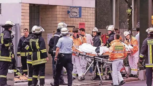  ?? FOTO: ULLSTEIN/AP ?? Rettungssa­nitäter und Feuerwehr kümmern sich im Juli 2000 nach der Explosion eines Sprengsatz­es an der Düsseldorf­er S-Bahn-Haltestell­e Wehrhahn um die Verletzten.