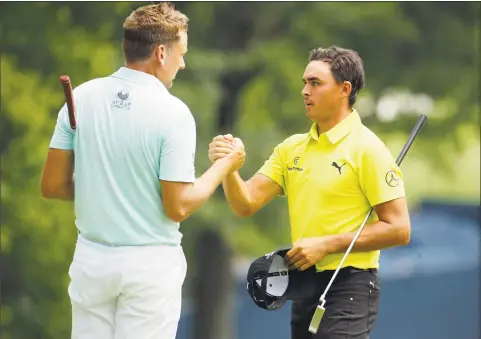  ?? Charlie Riedel / Associated Press ?? Ian Poulter, of England, left, shakes hands with Rickie Fowler, right, after completing their round during the first round of the PGA Championsh­ip golf tournament at Bellerive Country Club on Thursday in St. Louis.