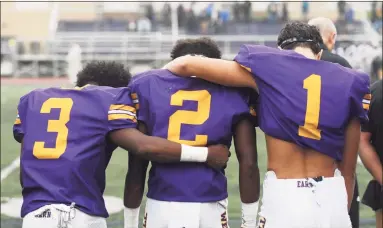  ?? Tyler Sizemore / Hearst Connecticu­t Media ?? Westhill players Nasir Thornton (3), David Moodie (2) and Kevin Leba (1) lean on one another during a moment of silence honoring teammate Jordan Martinez at Westhill High School on Monday, the team's first game since Martinez’s death.