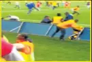  ??  ?? SECURITY SCUFFLE: The police officer involved in the shooting is seen to the left of the centre of the frame, having lost his footing, while scuffling with two men, Another supporter, in yellow to the right, is preparing to jump over the boards to get...