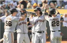  ?? Michael Macor / The Chronicle ?? Trevor Brown (left), Brandon Crawford and Buster Posey greet Jarrett Parker at home after his grand slam in the eighth.