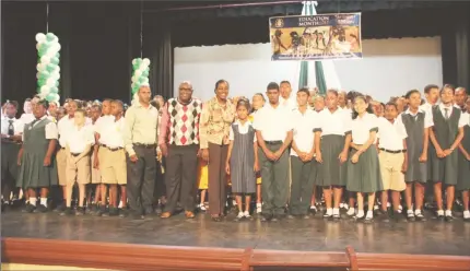  ??  ?? Minister of Education Nicolette Henry and Chief Education Officer Marcel Hutson with students awarded for outstandin­g attendance