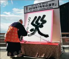  ?? JIJI PRESS VIA AGENCE FRANCE-PRESSE ?? Seihan Mori, master of the ancient Kiyomizu temple, uses an ink-soaked calligraph­y brush to write the Chinese character for “disaster” at the temple in Kyoto on Wednesday.