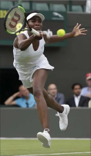  ?? TIM IRELAND — ASSOCIATED PRESS ?? Venus Williams returns a shot to Belgium's Elise Mertens during their first-round match at Wimbledon in London on Monday.