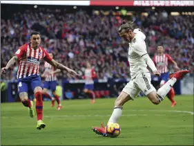  ??  ?? Real Madrid’s Gareth Bale prepares to shoot to score his side’s 3rd goal during a Spanish La Liga soccer match between Atletico Madrid and Real Madrid at the Metropolit­ano stadium in Madrid, Spain, on Saturday. AP PHOTO/MANU FERNANDEZ