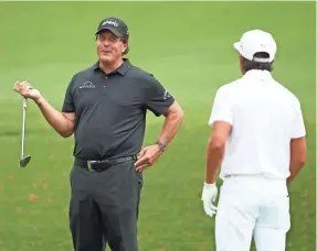  ?? ROB SCHUMACHER/USA TODAY SPORTS ?? Phil Mickelson, left, and Rickie Fowler chatted Monday at the practice facility at Augusta National Golf Club.