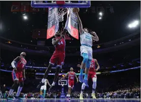  ?? MATT SLOCUM — THE ASSOCIATED PRESS ?? Charlotte’s Vasa Micic, right, goes up for a shot against the 76ers’ Paul Reed during the first half on Friday.