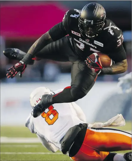  ?? — THE CANADIAN PRESS ?? B.C. Lions defending Bo Lokombo tries to tackle Calgary Stampeders running back Jerome Messam during the second half of the CFL Western Division semifinal in Calgary Sunday.