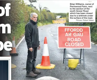  ?? Picture: Robert Melen ?? Brian Williams, owner of Perriswood Farm, next to the section of the south Gower Road which has been closed due to a sinkhole under the surface of the road.