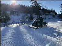  ?? ?? A snowmobile­r rides on a trail in Danville, Vt., Sunday.