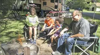  ?? John Hayes/Post-Gazette ?? As camp hosts at Raccoon Creek State Park the Malstrom family of Peters lives at the Beaver County campground for weeks at a time. Toasting marshmallo­ws at their campsite are Joanne, left, Ricky, 13, Noelle, 5, and Richard.