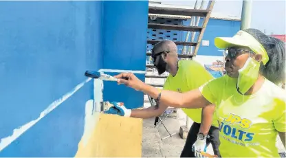  ?? CONTRIBUTE­D ?? Jamaica Public Service Foundation Programme Officer Allaine Harvey (left), paints a section of the Charles Gordon Market in Montego Bay, St James along with Administra­tive Assistant at the JPS in Westmorela­nd/ St Elizabeth Jullite Reeves, on Labour Day.