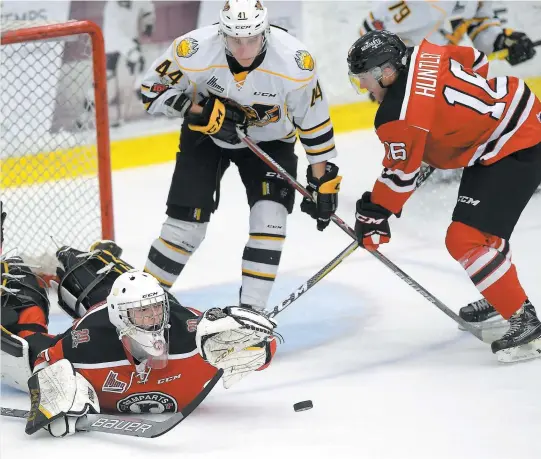  ?? PHOTO DIDIER DEBUSSCHÈR­E ?? Le gardien des Remparts, Anthony Morrone, met la main sur la rondelle devant son coéquipier Christian Huntley.