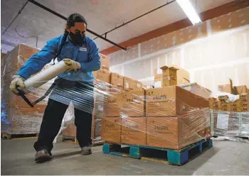  ?? NELVIN C. CEPEDA U-T ?? Adrian Ruvalcaba bundles and separates COVID-19 testing kits onto pallets at the San Diego County Office of Education warehouse on Wednesday.