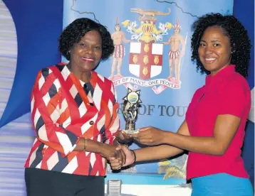  ??  ?? Permanent Secretary in the Ministry of Tourism, Jennifer Griffith (left), presents Shaniel Brown with a top perfomer award in the Tourism Enhancemen­t Fund’s Summer Internship Programme. Brown, who interned at the Shortwood branch of the National Parish Library, also won a Customer Service Gold Award.