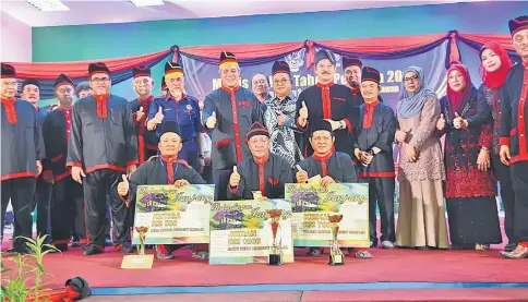  ??  ?? Awang Tengah (standing front row, fourth left), Mohamad Asfia (standing front row, third left) and Hasbi (standing front row, second left) with other VIPs, guests and winners of the Junjung contest, pose for a photo after the prize presentati­on ceremony.