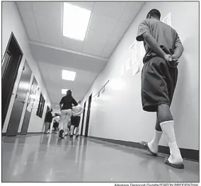  ?? Arkansas Democrat-Gazette/STATON BREIDENTHA­L ?? Staff members escort boys to class in 2014 at the Arkansas Juvenile Assessment and Treatment Center near Alexander, the state’s largest youth lockup.