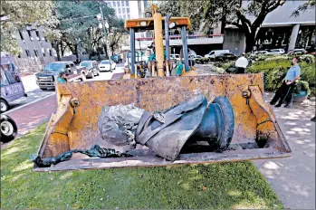  ?? MICHAEL DEMOCKER/GETTY ?? The statue of slaveholde­r John McDonough is removed Friday by city workers from a downtown park in New Orleans.