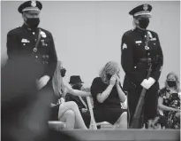  ?? Tribune News Service/los Angeles Times ?? Megan Flynn, right, is comforted during the August 2020 funeral of her domestic partner, LAPD Officer Valentin Martinez, the agency’s first sworn employee to die of complicati­ons from COVID-19, on Aug. 6, 2020, in Los Angeles.