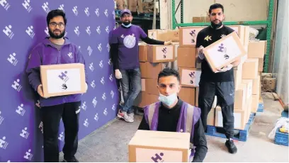  ??  ?? ●●Amir Khan (right) with Human Appeal volunteers in Rochdale with some of the completed packages