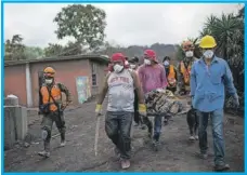  ??  ?? Rescatista­s cargan el cadáver de una persona hallada bajo los escombros y cenizas del Volcán de Fuego