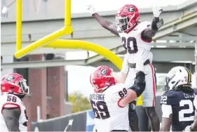  ?? AP PHOTO/GEORGE WALKER IV ?? Georgia running back Daijun Edwards, second from right, celebrates a touchdown with offensive lineman Tate Ratledge (69) during Saturday’s game against Vanderbilt in Nashville. Georgia won 37-20.