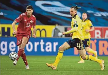  ?? AFP PIC ?? Sweden’s Zlatan Ibrahimovi­c (right) and Georgia’s Lasha Dvali vie for the ball during Thursday’s World Cup Group B qualifier at the Friends Arena in Stockholm.