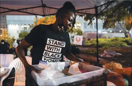  ?? DARRON CUMMINGS —THE ASSOCIATED PRESS ?? Rose Henderson helps out at a booth in Jefferson Square Park in Louisville, Ky. on Thursday. A grand jury has indicted one officer on criminal charges six months after Breonna Taylor was fatally shot by police in Kentucky.