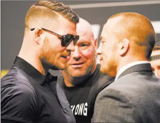  ?? Heidi Fang ?? Follow all of our MMA and UFC coverage online at Coveringth­ecage.com and @Coveringth­ecage on Twitter.
UFC middleweig­ht champion Michael Bisping, left, engages with Georges St-pierre during a staredown at the UFC 217 news conference Oct. 6 at T-mobile...