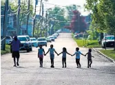  ?? MATT ROURKE THE ASSOCIATED PRESS FILE PHOTO ?? Children walk hand-in-hand on a street near the scene of a deadly shooting at a supermarke­t in Buffalo, N.Y.