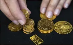  ?? (Neil Hall/Reuters) ?? GOLD COINS are displayed at Hatton Garden Metals precious-metals dealer in London.