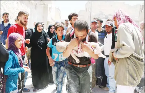  ??  ?? A Syrian man holds the body of his child after it was taken from under the rubble of destroyed buildings following a reported air strike on the rebel-held neighbourh­ood of al-Marjah in the northern city of Aleppo, on July 24. Air raids have hit four...