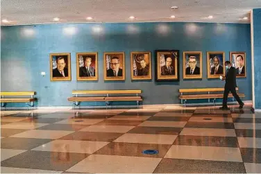  ?? Mary Altaffer / Associated Press ?? A man walk past portraits of former U.N. secretary-generals on Monday at a relatively empty United Nations headquarte­rs in New York. The internatio­nal organizati­on was created 75 years ago.