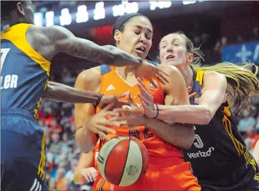  ?? DANA JENSEN/THE DAY ?? The Sun’s Brionna Jones, middle, is fouled by Jennifer Hamson of the Indiana Fever, right, as she goes up for a shot during a WNBA game at Mohegan Sun Arena on July 30.