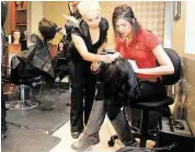  ?? Pin Lim: For the Chronicle ?? Instructor Odilia Zapata, left, and Chrissie Bou practice on a wig at Remington College Webster, which will offer free services to prom students.