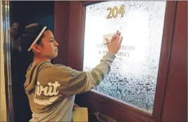  ?? AP PHOTO ?? Diana Hodges places a sticky note that calls for freeing 22-year old Daniela Vargas, a Argentine native who has lived in the United States since she was seven years old, on the office doors of lawmakers at the Capitol in Jackson, Miss.