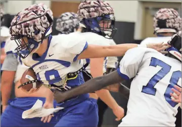  ?? Tommy Romanach / Rome News-Tribune ?? Model quarterbac­k Jackson Couch (18) tries to push his way through the defense during drills Tuesday inside the auxiliary gym at Model High School. The Blue Devils begin Region 7-AA play Friday on the road at Dade County.